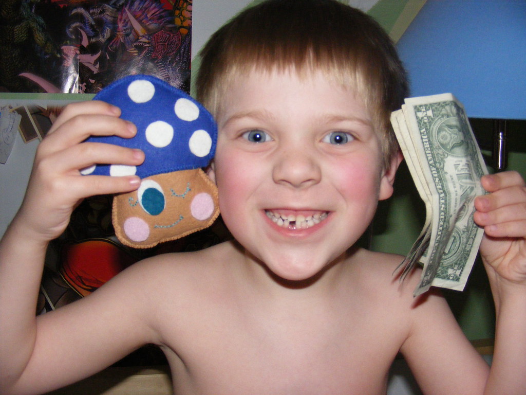 Excited kid with tooth fairy pillow and cash