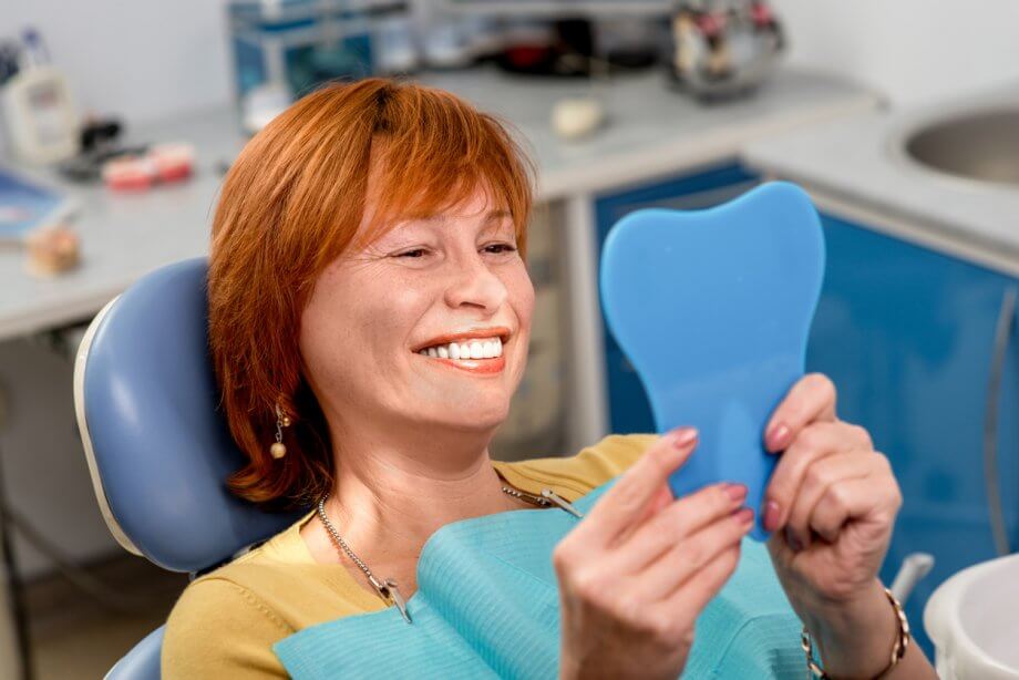 Woman looking at her smile after deep cleaning