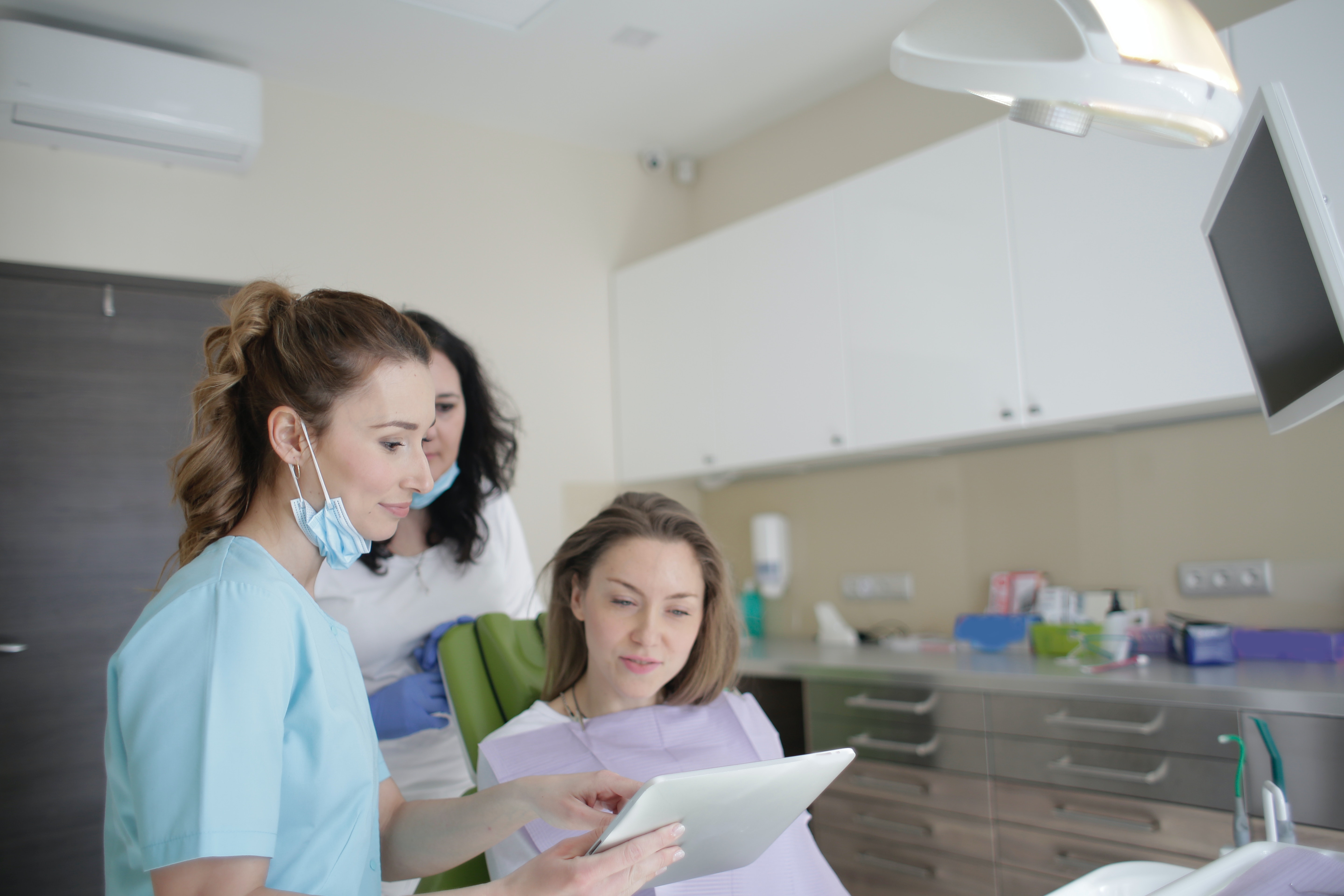Dentist consulting woman on dental implant process