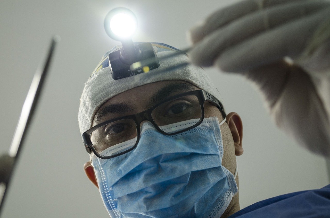 Dentist looking down at patient, filling a cavity