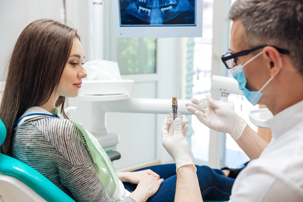 Dentist explaining dental implant procedure to a patient