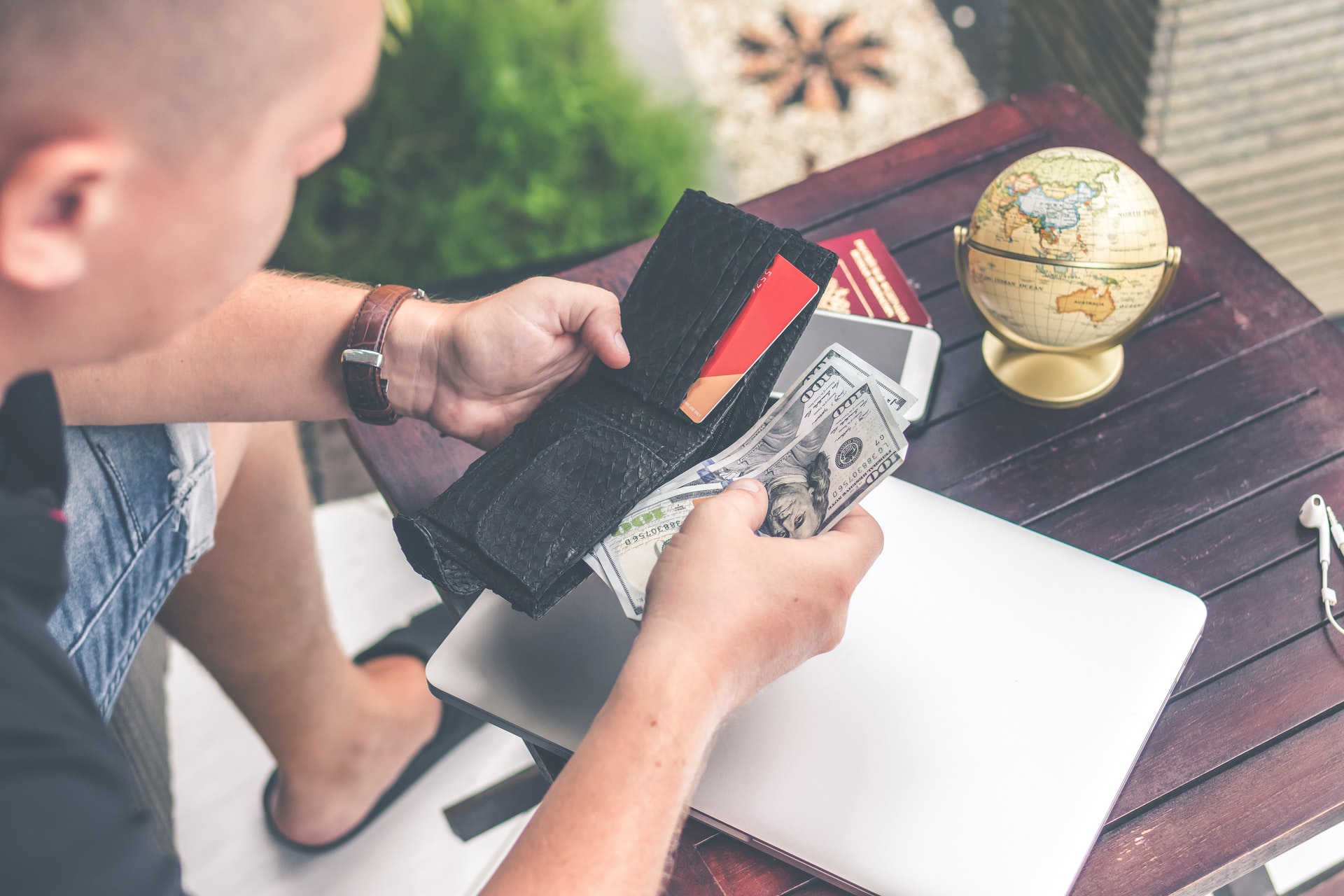 man holding wallet counting money trying to figure out invisalign cost and budget