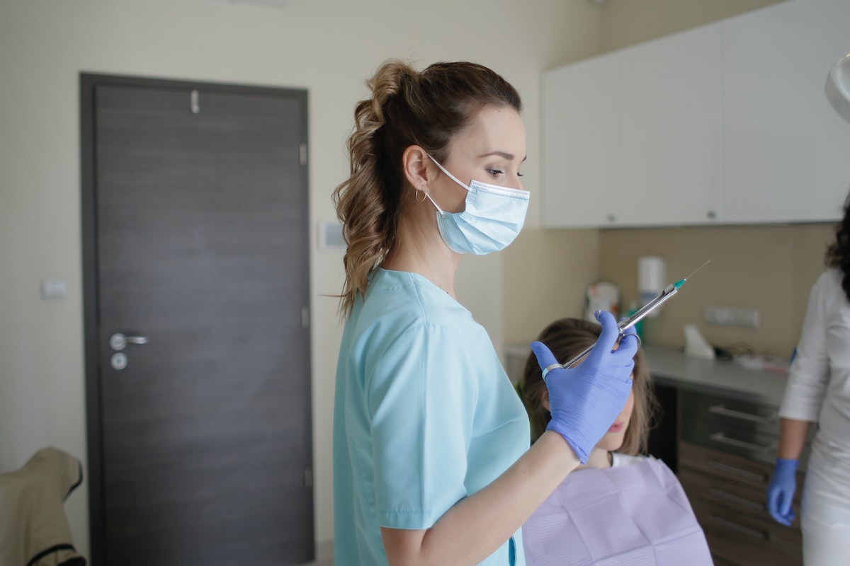 Dentist preparing Novocaine shot to minimize pain during dental filling