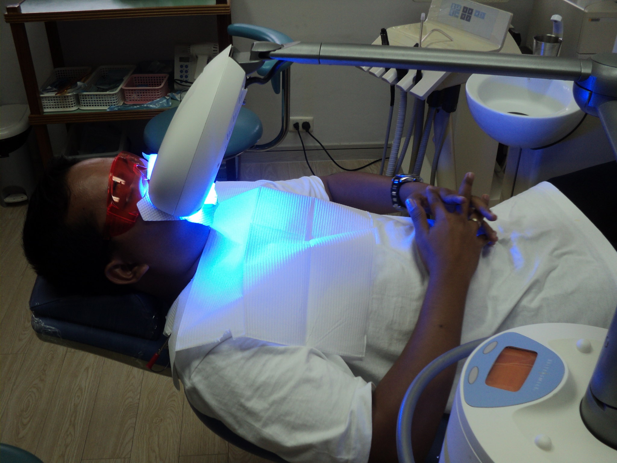Person receiving laser teeth whitening treatment at dentist office